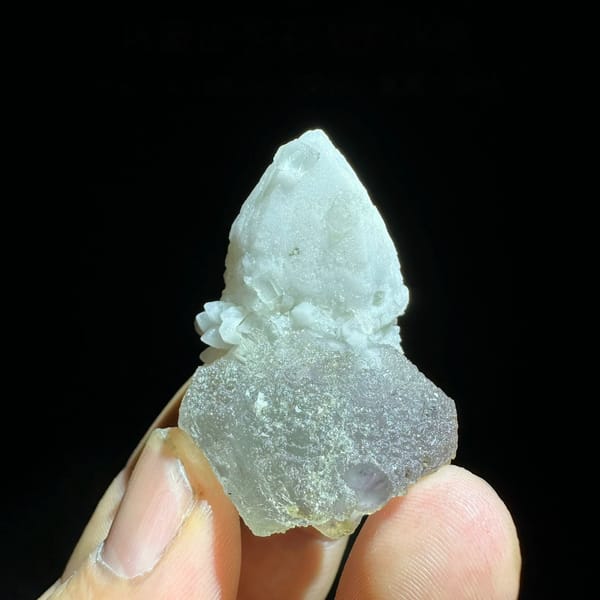 Pale blue-green fluorite enclosing candle quartz from Inner Mongolia, China, held in hand