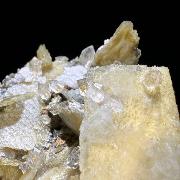 Phantom scepter quartz among tan platy calcite from Inner Mongolia, China, close-up of the crystal faces