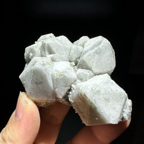 Large blocky white quartz crystals with bright skin from Inner Mongolia, China, held in hand