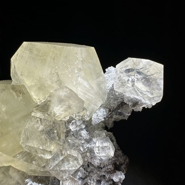 Glassy transparent calcite crystals on dark grey quartz from Fujian, China, close-up of the crystal faces