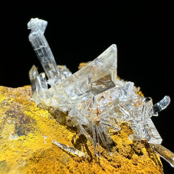 Ultra-clear gypsum blades on ochre-yellow rock from Guizhou, China, top view