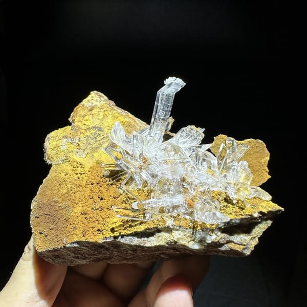 Ultra-clear gypsum blades on ochre-yellow rock from Guizhou, China, detail of the matrix contact