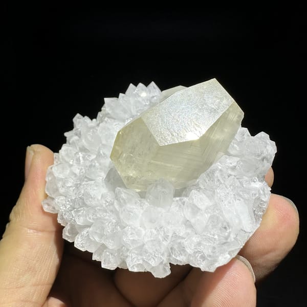 Large golden calcite crystal in nest of white quartz points from Fujian, China, detail of the matrix contact