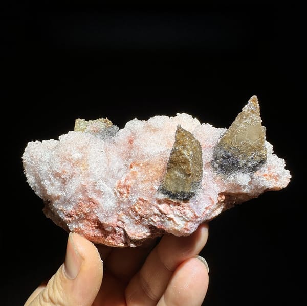 Coffee-brown calcite spikes on pink gypsum from Guizhou, China, detail of the matrix contact