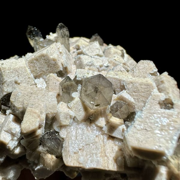 Smoky scepter quartz among cream feldspar from Yunxiao, Fujian, China, close-up of the crystal faces