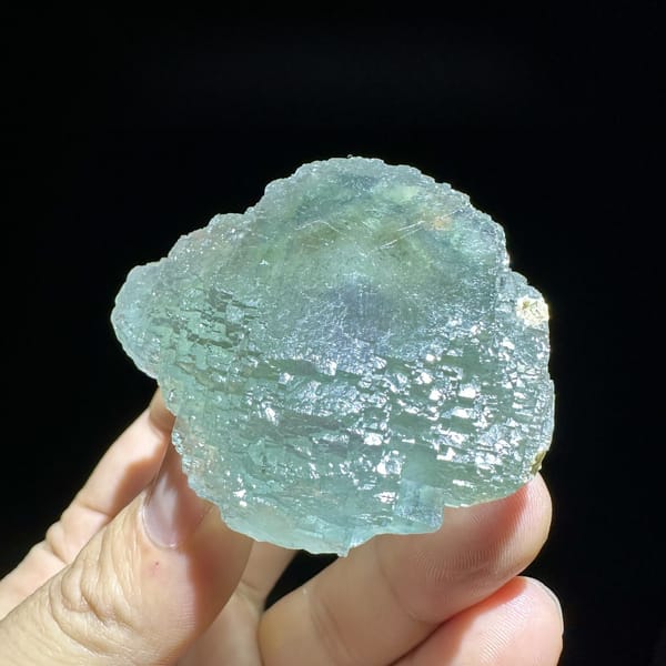 Large sea-green fluorite crystal with purple core from Guangxi, China, detail of the matrix contact