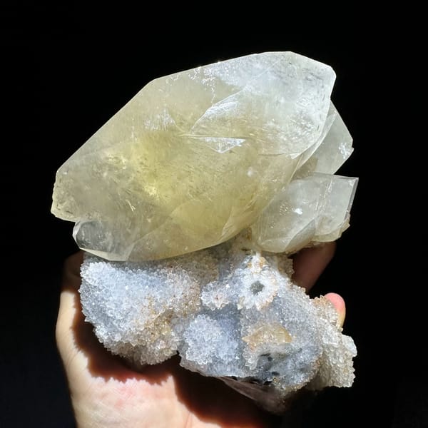 Huge golden calcite crystal on white quartz druse from Fujian, China, close-up of the crystal faces