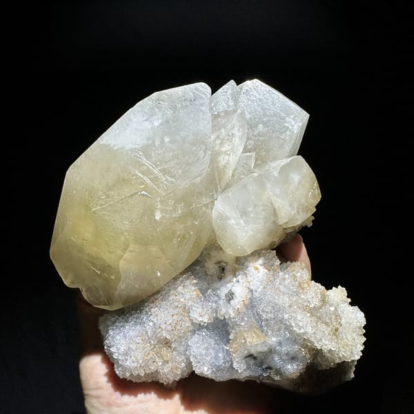 Huge golden calcite crystal on white quartz druse from Fujian, China, detail of the matrix contact