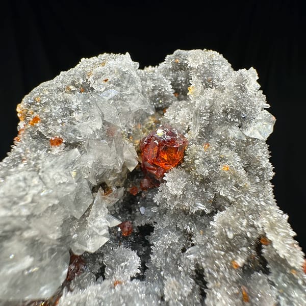 Red gem sphalerite crystals on grey calcite and quartz from Hunan, China, close-up of the crystal faces