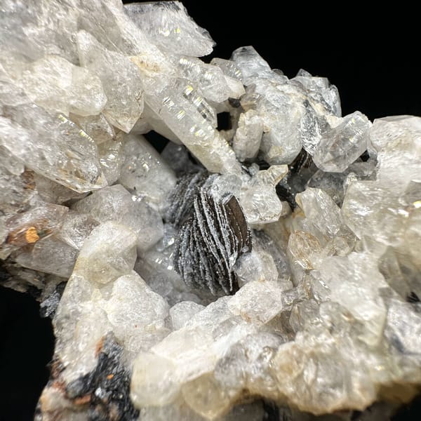 Tower of sugar-textured white quartz with black specular hematite from Guangdong, China, close-up of the crystal faces