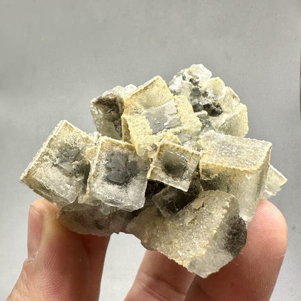 Etched cream fluorite cubes with sugary skin from Fujian, China, detail of the matrix contact