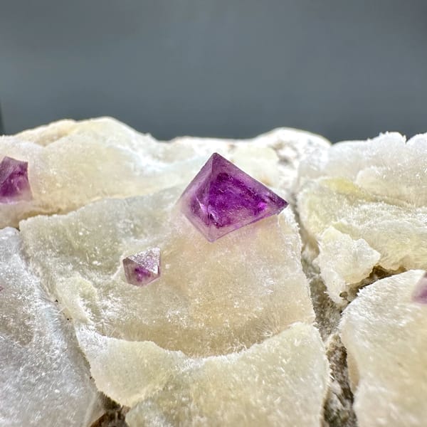 Cream fluorite octahedra with purple-red fluorite on quartz from Zhejiang, China, second angle