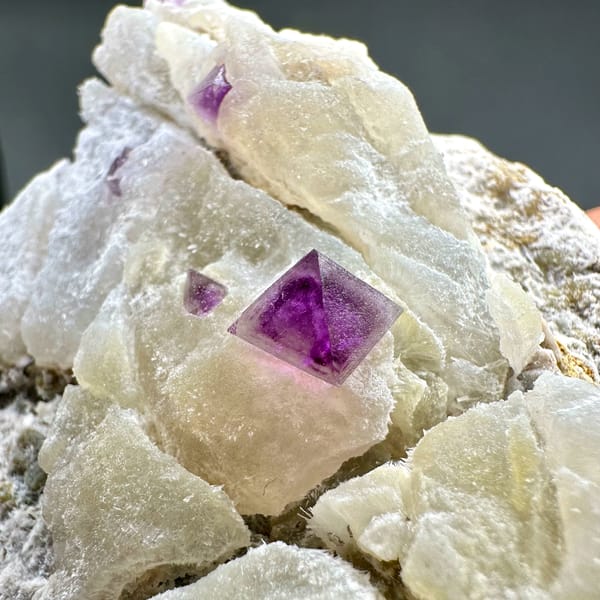 Cream fluorite octahedra with purple-red fluorite on quartz from Zhejiang, China, reverse side