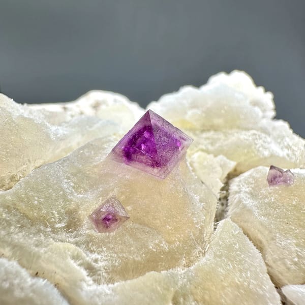 Cream fluorite octahedra with purple-red fluorite on quartz from Zhejiang, China, top view