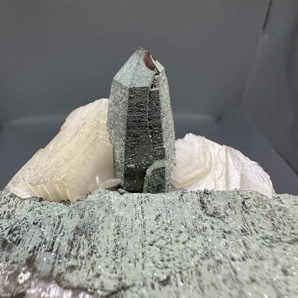 Clear quartz point on green chlorite block with calcite from Yunxiao, Fujian, China, close-up of the crystal faces
