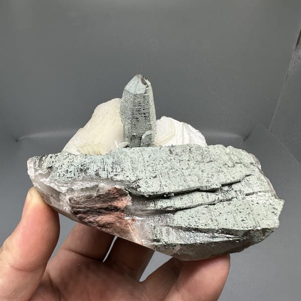 Clear quartz point on green chlorite block with calcite from Yunxiao, Fujian, China, detail of the matrix contact