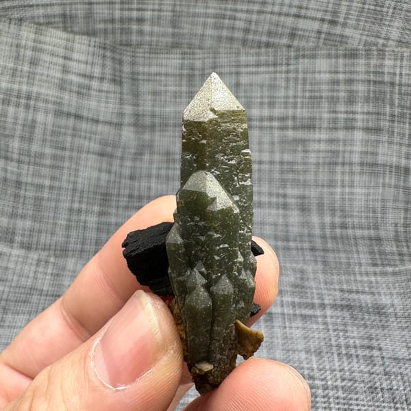 Green chlorite-coated quartz point on black matrix from Inner Mongolia, China, second angle