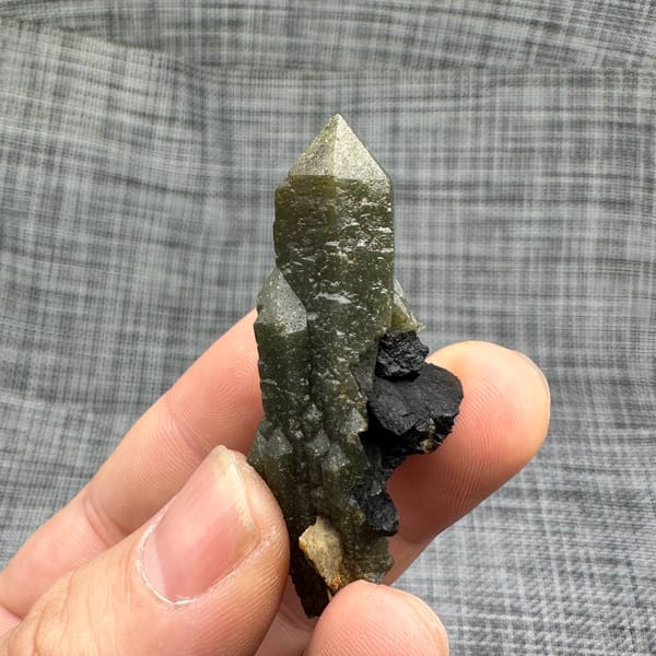 Green chlorite-coated quartz point on black matrix from Inner Mongolia, China, reverse side