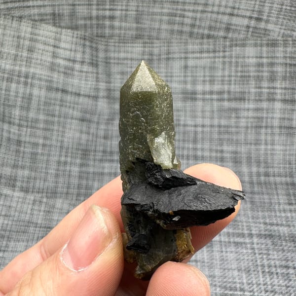Green chlorite-coated quartz point on black matrix from Inner Mongolia, China, top view
