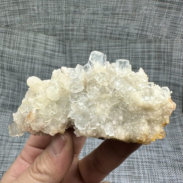 Colourless fluorite cubes on quartz plate from Guizhou, China, detail of the matrix contact
