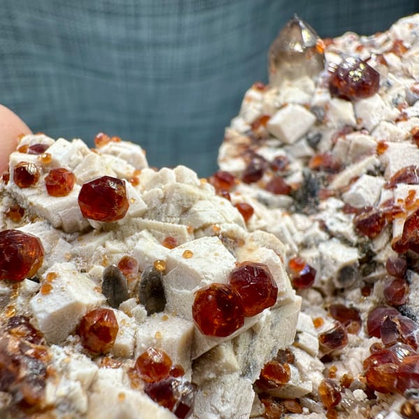 Feldspar plate peppered with wine-red garnets from Yunxiao, Fujian, China, close-up of the crystal faces