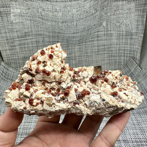 Feldspar plate peppered with wine-red garnets from Yunxiao, Fujian, China, detail of the matrix contact