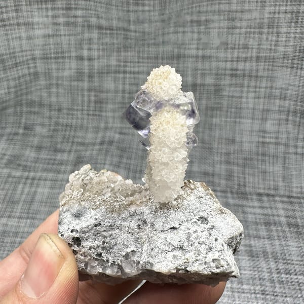 Blue-green fluorite dodecahedron on white quartz stalk from Fujian, China, detail of the matrix contact