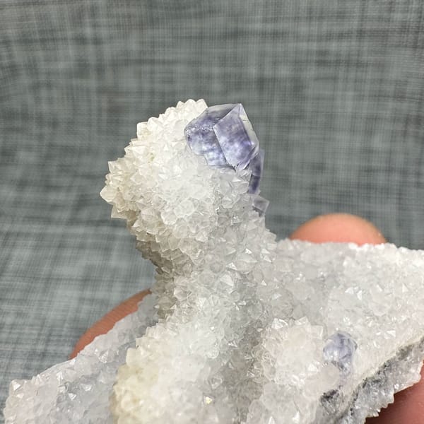 Purple-blue fluorite dodecahedron on white quartz mound from Fujian, China, top view