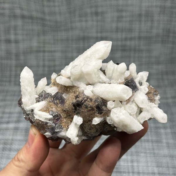 White candle quartz prisms with purple fluorite octahedron from Inner Mongolia, China, close-up of the crystal faces