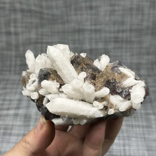 White candle quartz prisms with purple fluorite octahedron from Inner Mongolia, China, detail of the matrix contact