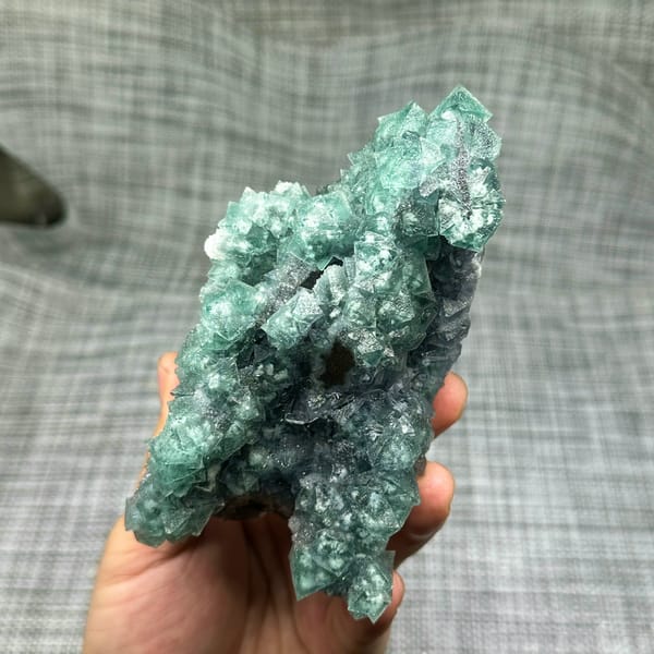 Teal-green octahedral fluorite with snowflake inclusions from Fujian, China, close-up of the crystal faces
