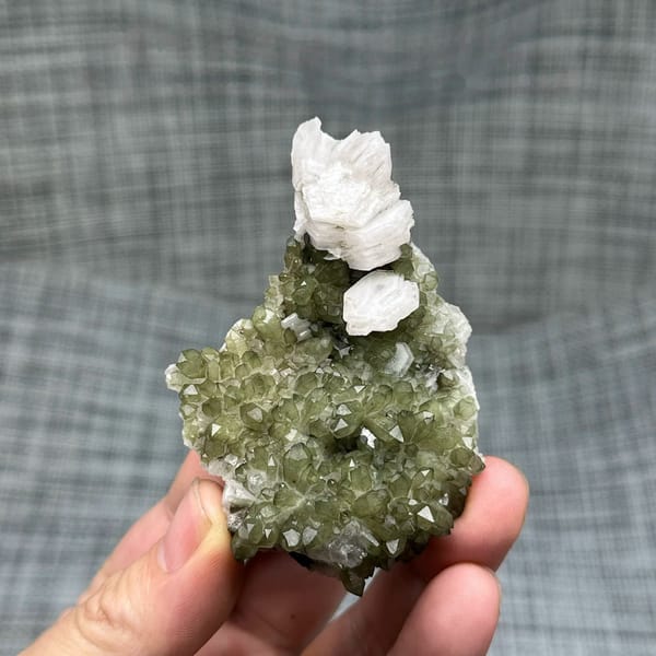 Green chlorite-coated quartz with white hexagonal calcite from Fujian, China, held in hand