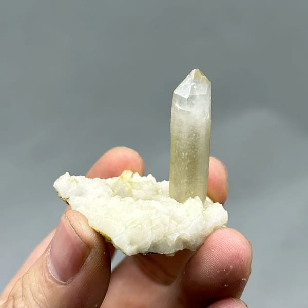 Gradient quartz point standing on white feldspar from Yunxiao, Fujian, China, top view