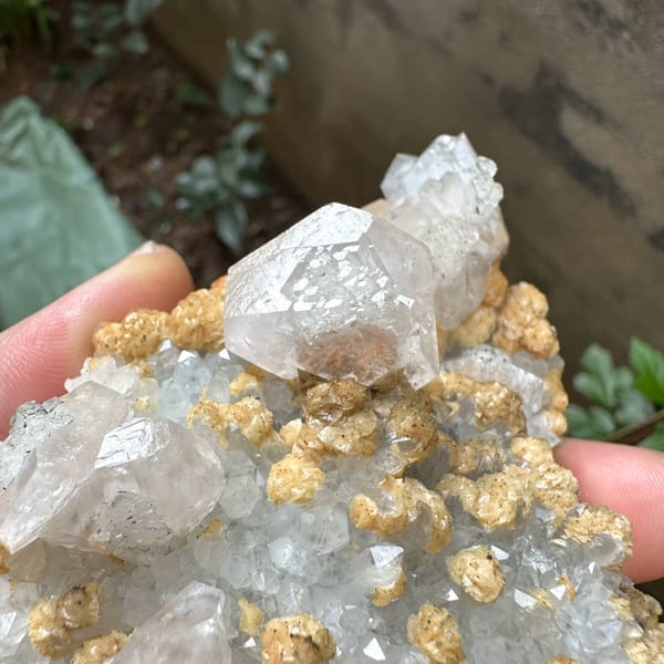 Pale pink calcite with tan dolomite crusts from Jiangxi, China, close-up of the crystal faces