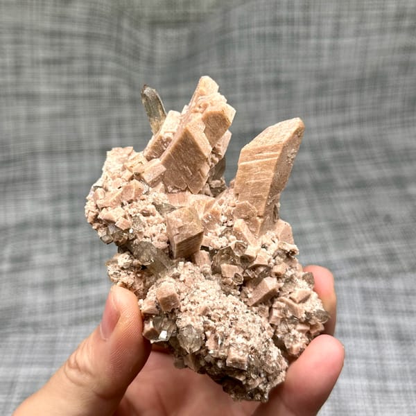 Salmon-pink prismatic feldspar crystals with smoky quartz from Yunxiao, Fujian, China, close-up of the crystal faces