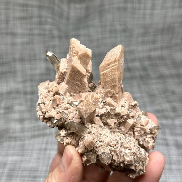 Salmon-pink prismatic feldspar crystals with smoky quartz from Yunxiao, Fujian, China, detail of the matrix contact