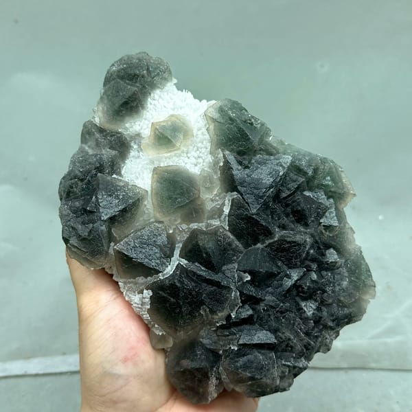 Dark green octahedral fluorite with white stepped fluorite from Zhejiang, China, close-up of the crystal faces
