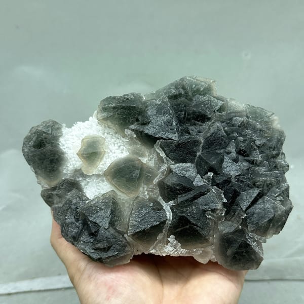 Dark green octahedral fluorite with white stepped fluorite from Zhejiang, China, detail of the matrix contact