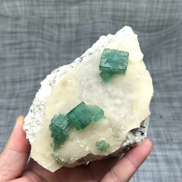 Emerald-green daylight fluorite cubes on cream quartz plate from Madagascar, top view