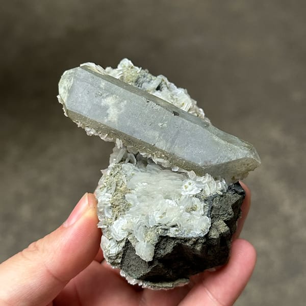 Grey double-terminated quartz on coin-shaped calcite from Inner Mongolia, China, reverse side