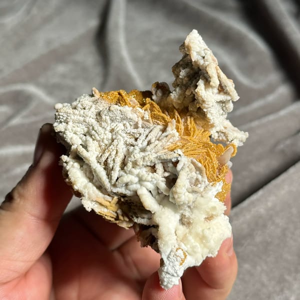 Orange-yellow mimetite on white aragonite and baryte from Morocco, close-up of the crystal faces