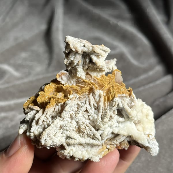 Orange-yellow mimetite on white aragonite and baryte from Morocco, detail of the matrix contact