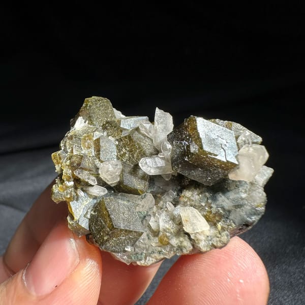Interpenetrant-twinned garnet crystals with quartz from Inner Mongolia, China, held in hand
