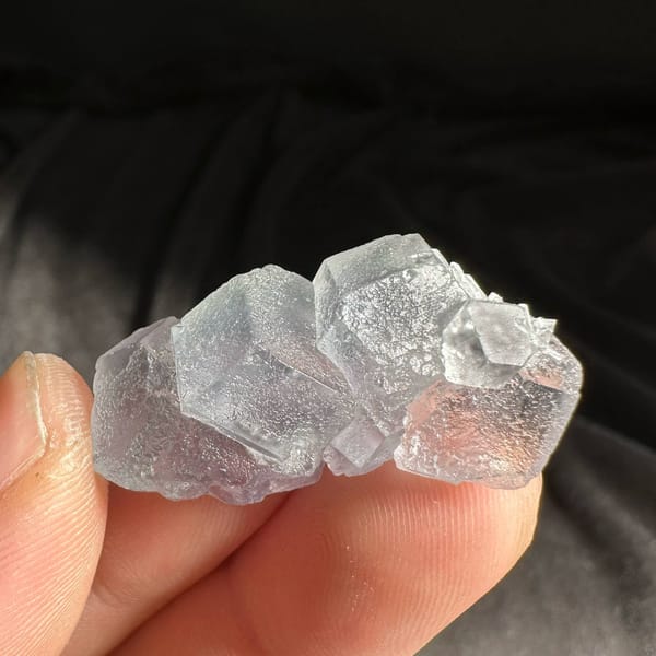 Pale blue-green fluorite cube group from Fujian, China, held in hand
