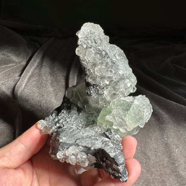 Mountain-shaped pale green fluorite cluster on dark quartz from Fujian, China, reverse side