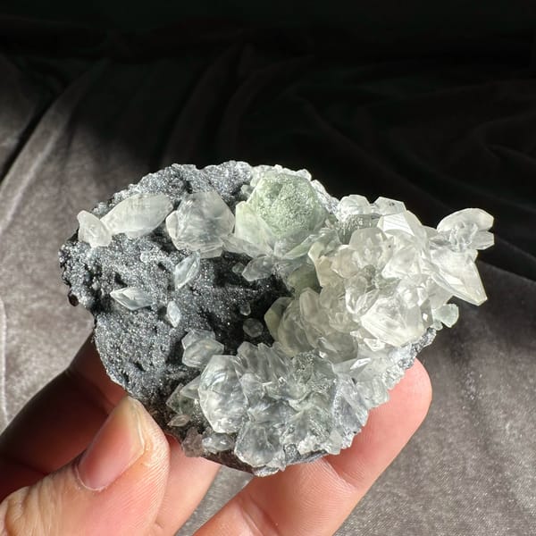 Clear star-patterned calcite with green fluorite on dark druse from Fujian, China, top view