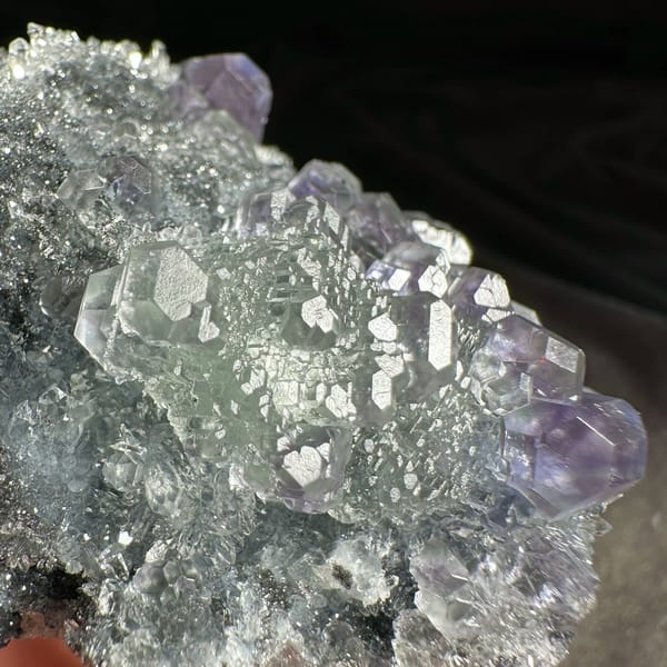 Stepped purple and green fluorite cubes on grey quartz druse from Fujian, China, second angle