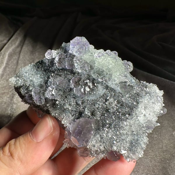 Stepped purple and green fluorite cubes on grey quartz druse from Fujian, China, top view