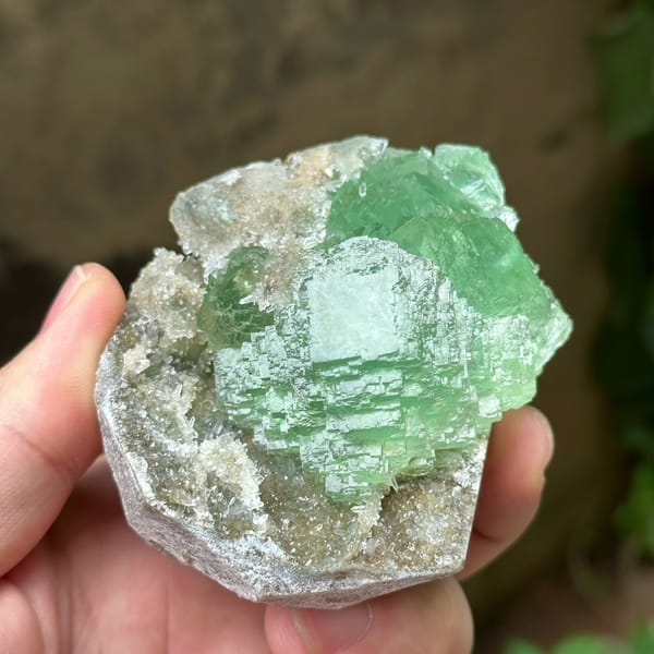 Cross-shaped stack of transparent green fluorite cubes from Fujian, China, close-up of the crystal faces