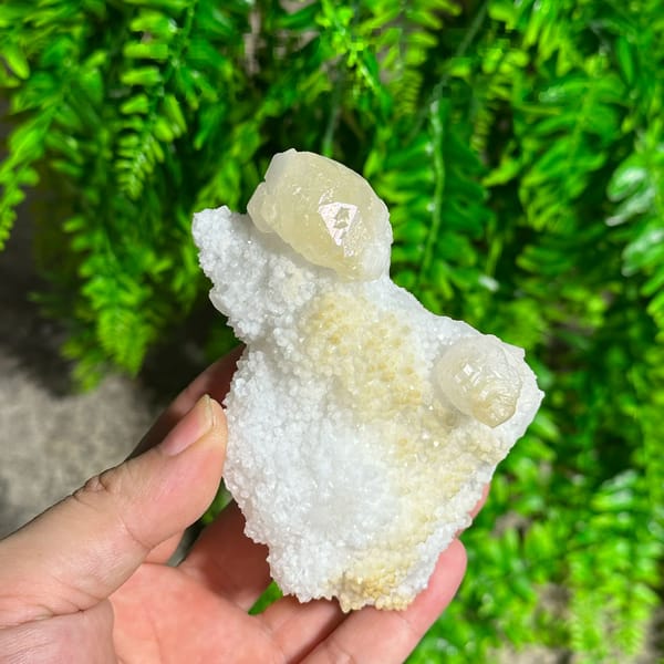 Iridescent calcite spire on sparkling white quartz from Fujian, China, held in hand